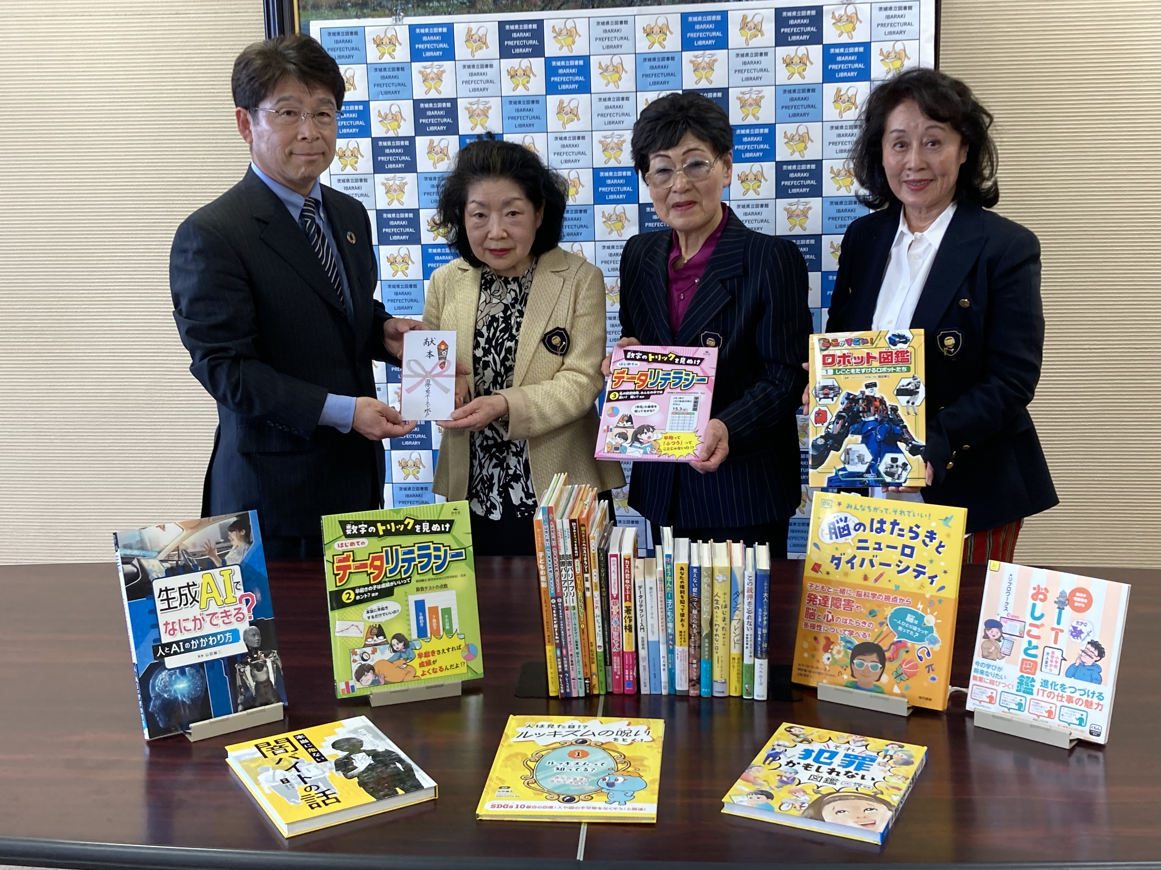 寄贈式の様子。４人の人物が本を手に持っている。左の男性が茨城県立図書館長、３人の女性が国際ソロプチミスト水戸のメンバー。